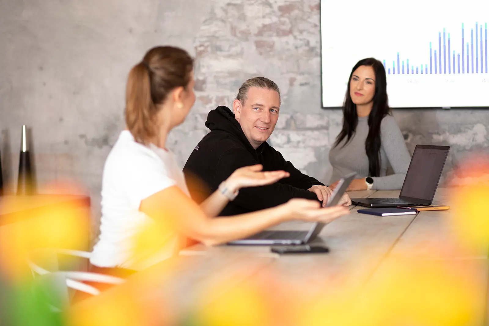 Drei Personen von SCALARA am Konferenztisch, im Hintergrund eine Auswertung auf dem Bildschirm.